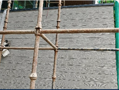 Wooden pattern textured concrete wall with scaffolding